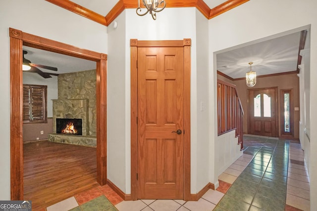341 Fox Rd, Griffin, GA 30224 - entryway with crown molding, tile patterned flooring, baseboards, a chandelier, and a fireplace