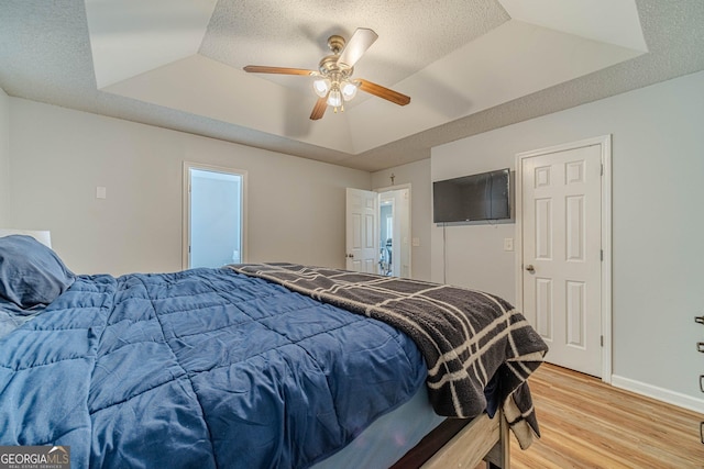 463 Rebekah Dr, Bethlehem, GA 30620 - bedroom with a tray ceiling, a ceiling fan, light wood-style flooring, and baseboards