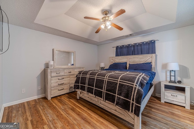 463 Rebekah Dr, Bethlehem, GA 30620 - bedroom featuring wood finished floors, visible vents, ceiling fan, a raised ceiling, and baseboards