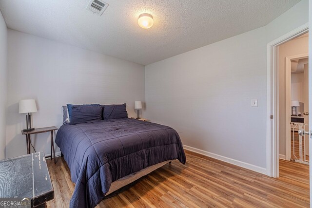 463 Rebekah Dr, Bethlehem, GA 30620 - bedroom featuring a textured ceiling, baseboards, visible vents, and light wood-style floors