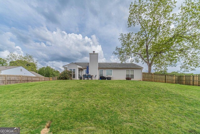 463 Rebekah Dr, Bethlehem, GA 30620 - back of house featuring a yard, a chimney, and a fenced backyard