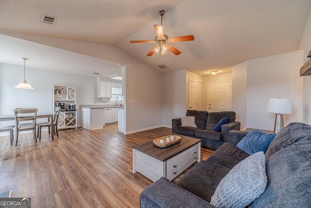 463 Rebekah Dr, Bethlehem, GA 30620 - living area with vaulted ceiling, light wood finished floors, a ceiling fan, and visible vents