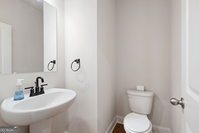 63 Brookstone Park E, Acworth, GA 30101 - half bathroom featuring toilet, a sink, baseboards, and wood finished floors