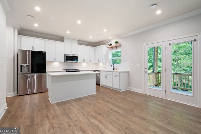 63 Brookstone Park E, Acworth, GA 30101 - kitchen with stainless steel appliances, decorative backsplash, light countertops, ornamental molding, and light wood-type flooring