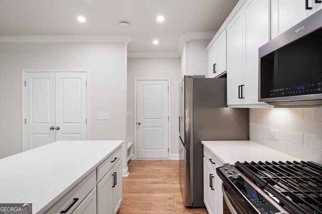 63 Brookstone Park E, Acworth, GA 30101 - kitchen with appliances with stainless steel finishes, white cabinetry, decorative backsplash, ornamental molding, and recessed lighting