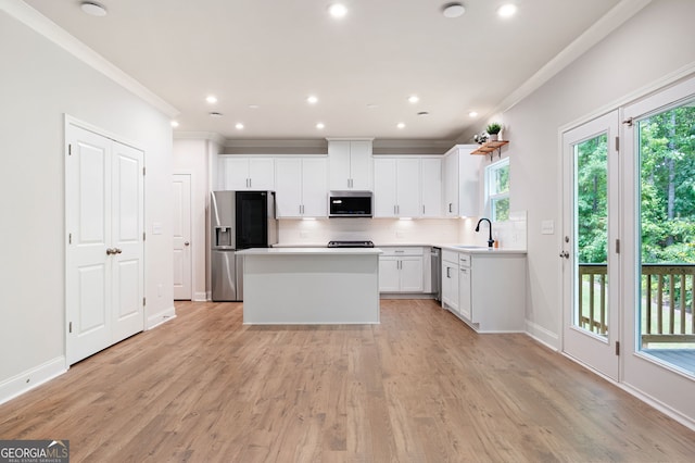 63 Brookstone Park E, Acworth, GA 30101 - kitchen featuring appliances with stainless steel finishes, crown molding, tasteful backsplash, a center island, and plenty of natural light