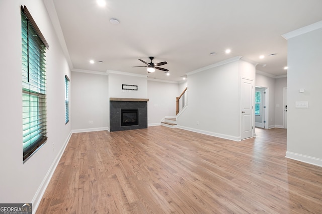 63 Brookstone Park E, Acworth, GA 30101 - unfurnished living room with recessed lighting, a ceiling fan, light wood-style floors, a glass covered fireplace, and ornamental molding