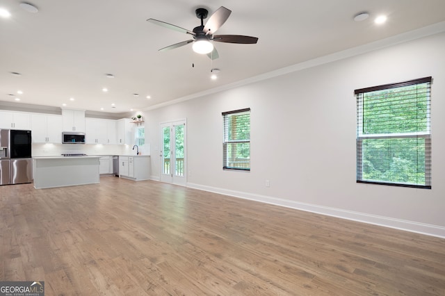 63 Brookstone Park E, Acworth, GA 30101 - unfurnished living room featuring ornamental molding, a sink, light wood-type flooring, baseboards, and recessed lighting
