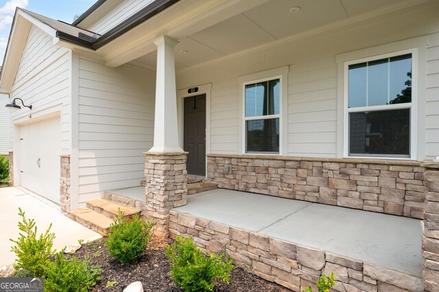 63 Brookstone Park E, Acworth, GA 30101 - property entrance with stone siding, covered porch, and a garage