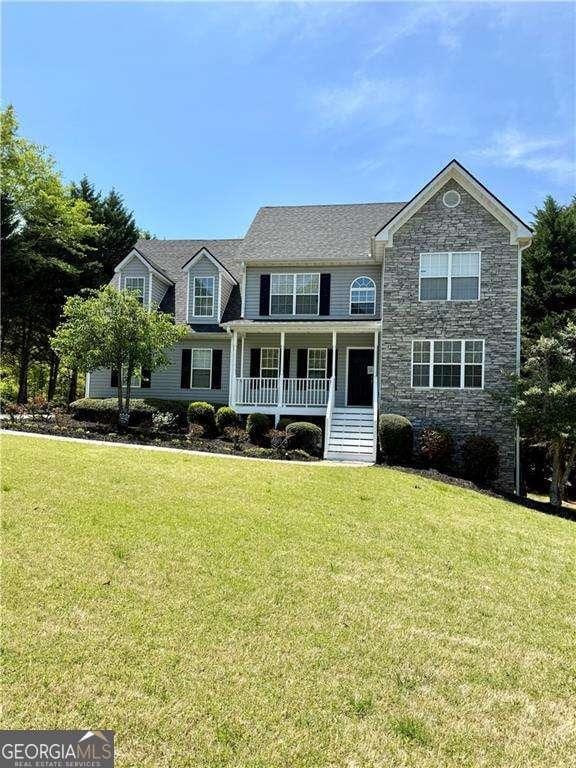 6945 Autumn Hills Dr, Cumming, GA 30028 - view of front facade featuring a porch, stone siding, and a front yard