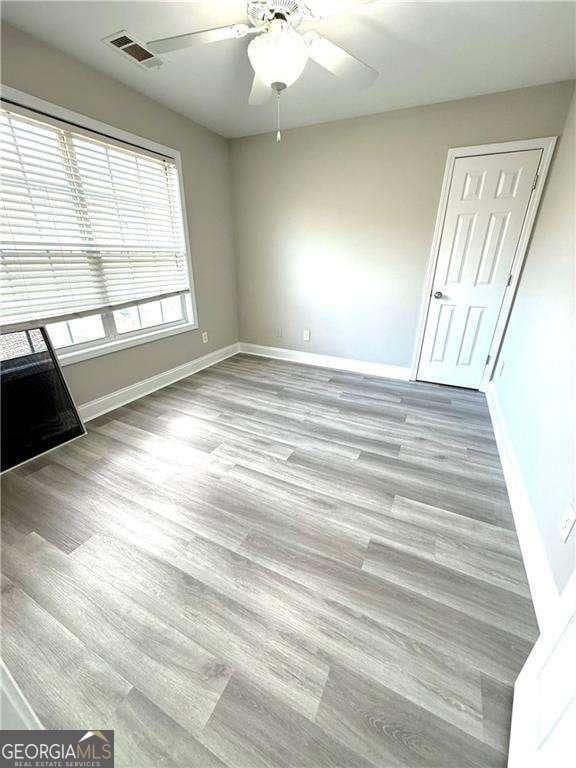6945 Autumn Hills Dr, Cumming, GA 30028 - unfurnished bedroom featuring ceiling fan, baseboards, visible vents, and wood finished floors