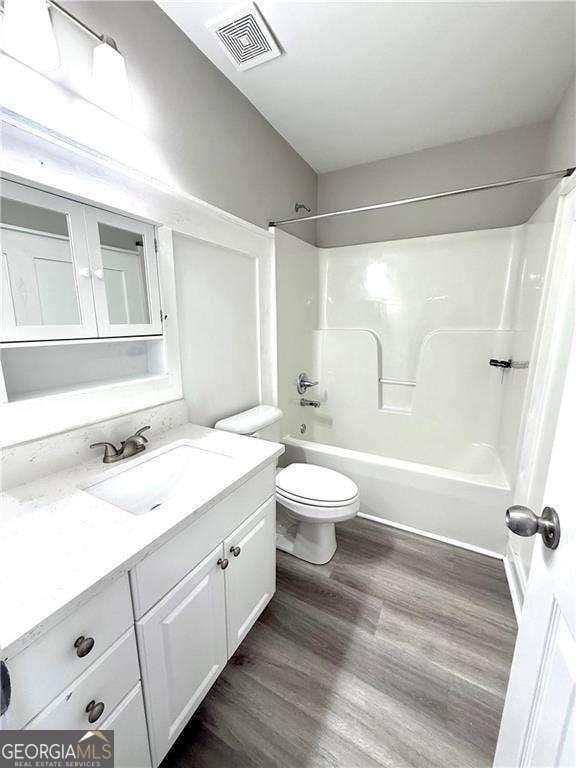 6945 Autumn Hills Dr, Cumming, GA 30028 - bathroom featuring toilet, wood finished floors, bathtub / shower combination, visible vents, and vanity
