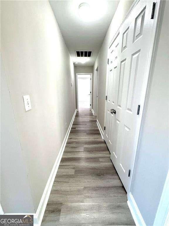 6945 Autumn Hills Dr, Cumming, GA 30028 - hall featuring baseboards, visible vents, and wood finished floors