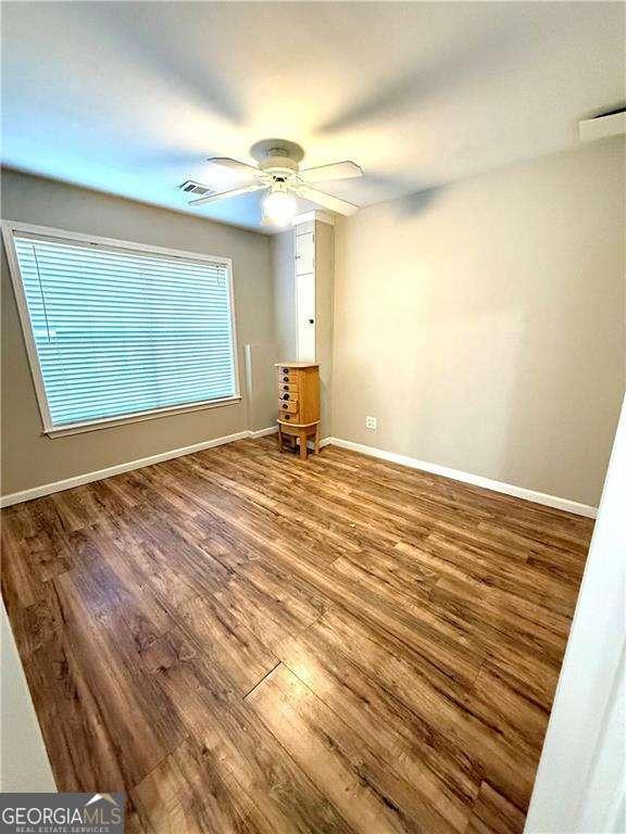 6945 Autumn Hills Dr, Cumming, GA 30028 - empty room featuring visible vents, wood finished floors, baseboards, and ceiling fan