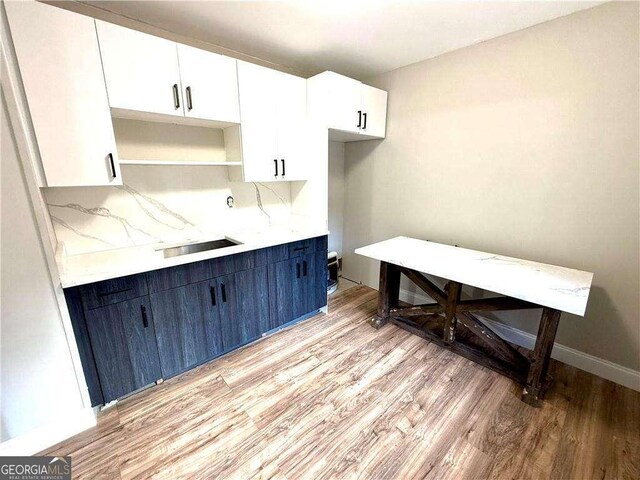 6945 Autumn Hills Dr, Cumming, GA 30028 - kitchen with blue cabinets, white cabinetry, light countertops, and light wood-style floors