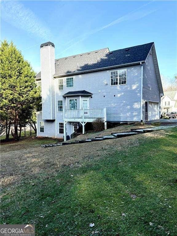 6945 Autumn Hills Dr, Cumming, GA 30028 - back of house with a deck, a chimney, and a lawn