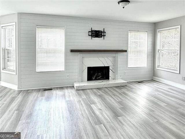 6945 Autumn Hills Dr, Cumming, GA 30028 - unfurnished living room featuring wood finished floors, visible vents, a fireplace, wooden walls, and baseboards
