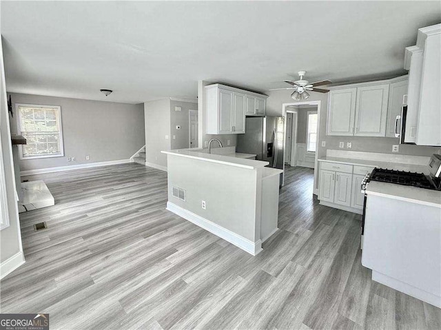 6945 Autumn Hills Dr, Cumming, GA 30028 - kitchen featuring light wood-type flooring, visible vents, light countertops, a ceiling fan, and appliances with stainless steel finishes