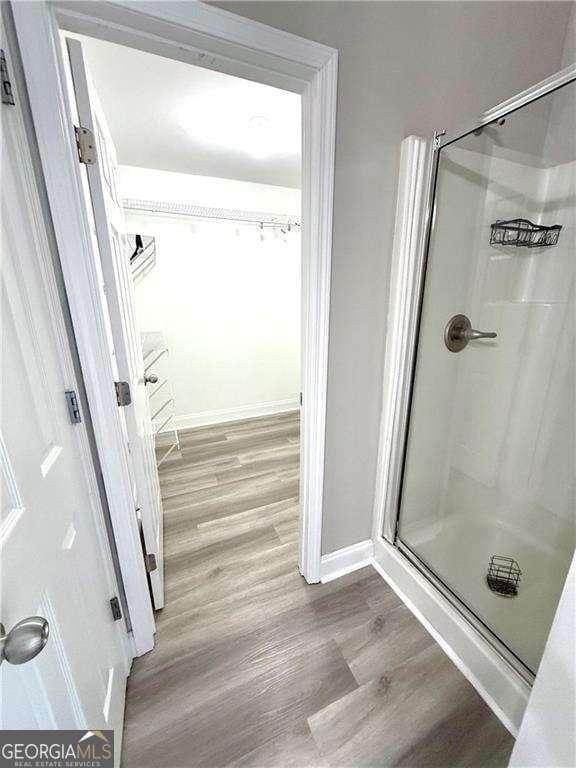 6945 Autumn Hills Dr, Cumming, GA 30028 - bathroom featuring a shower stall, baseboards, and wood finished floors