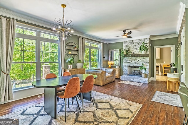 1122 Irongate, Macon, GA 31220 - dining area featuring crown molding, wood-type flooring, ceiling fan with notable chandelier, and a stone fireplace