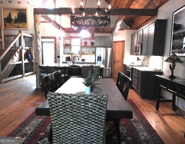 dining space with a notable chandelier, beam ceiling, high vaulted ceiling, and hardwood / wood-style flooring