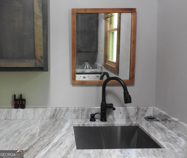 room details with light stone counters and a sink