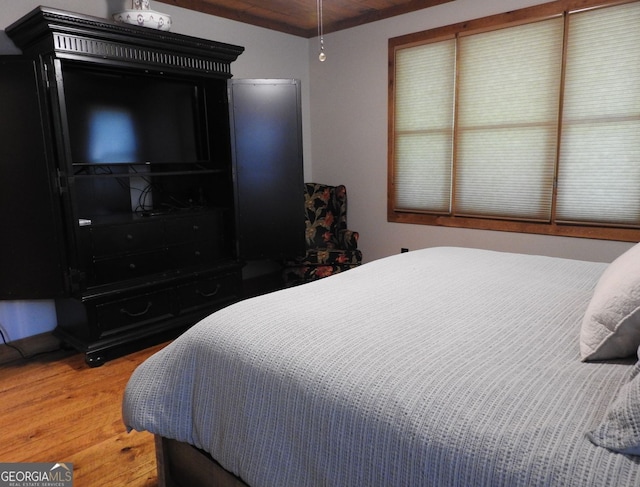 bedroom with wooden ceiling and light wood-type flooring