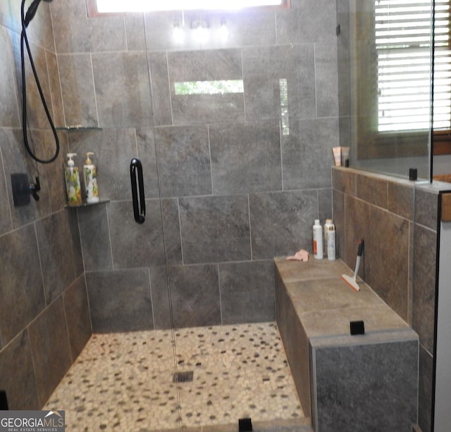 bathroom with a shower stall and a wealth of natural light