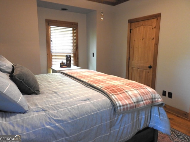 bedroom featuring baseboards and wood finished floors