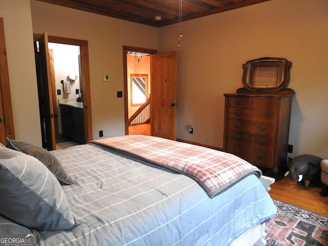 bedroom featuring ensuite bath, wooden ceiling, and wood finished floors