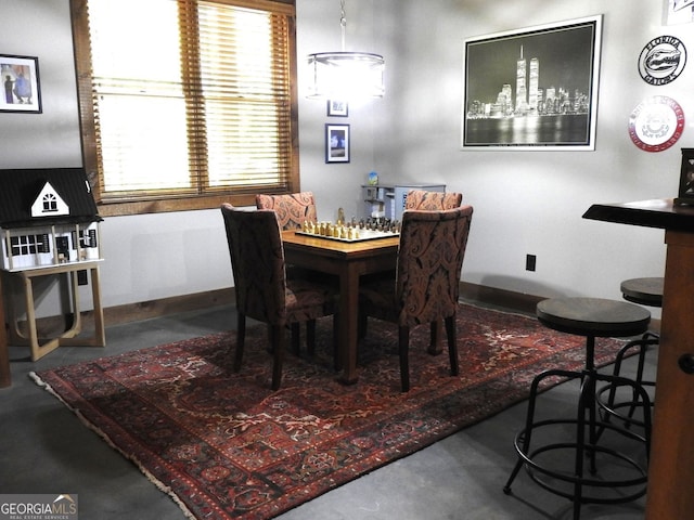 dining area with finished concrete flooring and baseboards