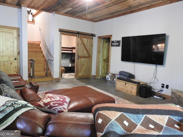 living area featuring concrete floors, a ceiling fan, a barn door, wooden ceiling, and stairs
