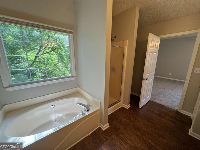 1048 Brandon Ln, Stone Mountain, GA 30083 - bathroom featuring a bath, baseboards, wood finished floors, and a stall shower
