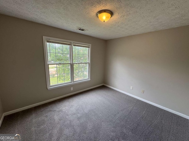 1048 Brandon Ln, Stone Mountain, GA 30083 - empty room with dark colored carpet, a textured ceiling, baseboards, and visible vents