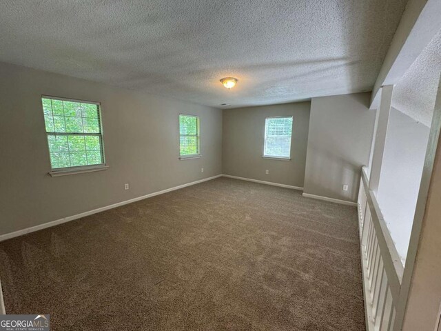 4911 Hairston Pl, Stone Mountain, GA 30088 - unfurnished room with a textured ceiling and dark carpet
