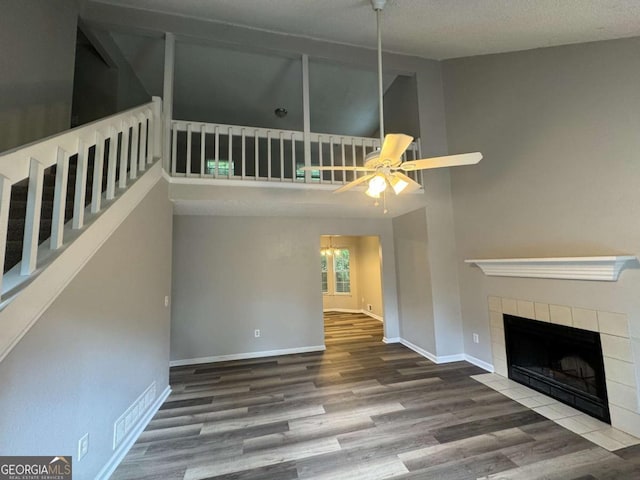 4911 Hairston Pl, Stone Mountain, GA 30088 - unfurnished living room with wood finished floors, a fireplace, a ceiling fan, stairs, and a high ceiling