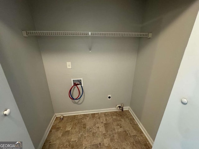 laundry room featuring laundry area, hookup for an electric dryer, stone finish floor, washer hookup, and baseboards