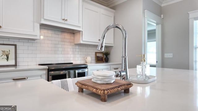 216 Morningside Dr, Thomasville, GA 31792 - kitchen with white cabinetry, stainless steel electric stove, light countertops, decorative backsplash, and ornamental molding