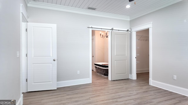216 Morningside Dr, Thomasville, GA 31792 - unfurnished bedroom with crown molding, a closet, light wood-style flooring, and a spacious closet