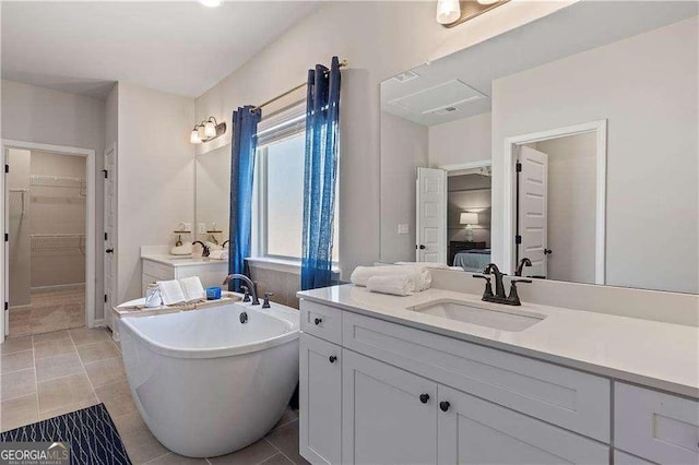 bathroom featuring vanity, ensuite bath, tile patterned flooring, and a freestanding tub