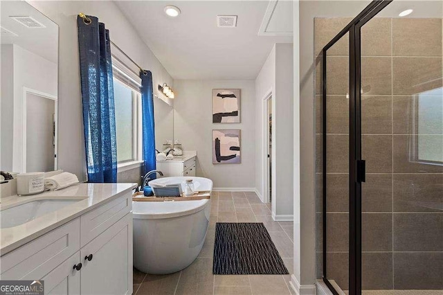 bathroom featuring a stall shower, visible vents, a sink, tile patterned floors, and a freestanding bath
