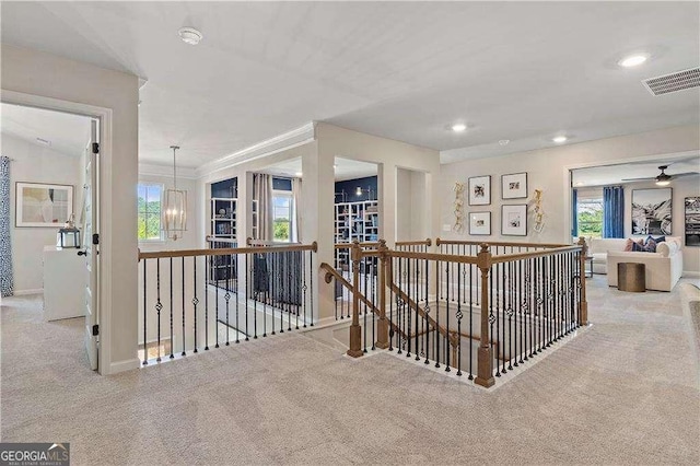 hallway featuring a healthy amount of sunlight, carpet flooring, an upstairs landing, and visible vents
