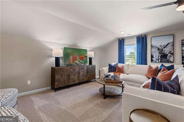 living area featuring carpet floors, visible vents, baseboards, ceiling fan, and vaulted ceiling
