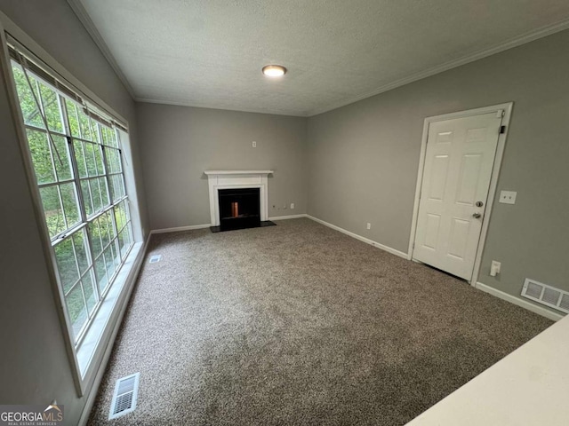 unfurnished living room featuring carpet flooring, baseboards, a fireplace with flush hearth, and visible vents