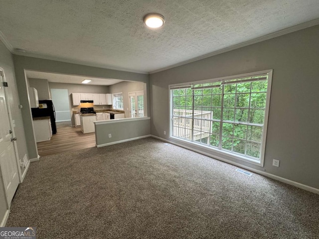 unfurnished living room featuring crown molding, a textured ceiling, dark colored carpet, and baseboards