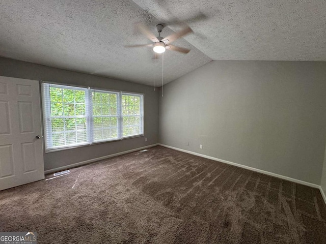 carpeted spare room featuring a textured ceiling, visible vents, baseboards, ceiling fan, and vaulted ceiling