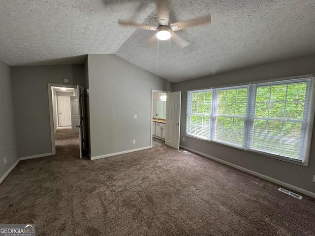 unfurnished bedroom with a textured ceiling, baseboards, lofted ceiling, and carpet floors