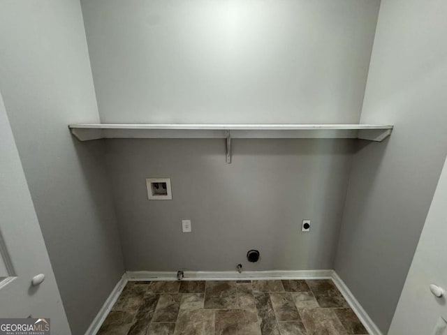 laundry room featuring electric dryer hookup, stone finish floor, gas dryer hookup, hookup for a washing machine, and baseboards