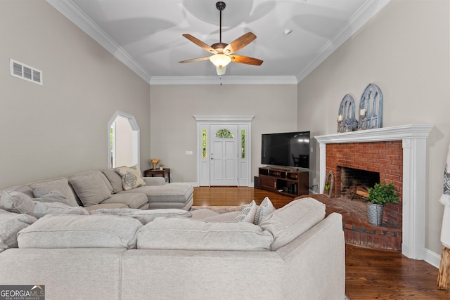 living room featuring crown molding, visible vents, a ceiling fan, and dark wood-style floors