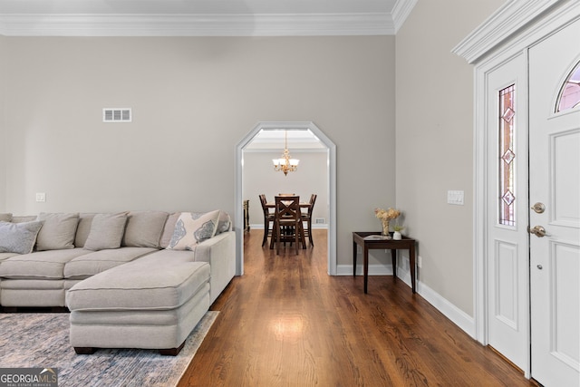 living room with visible vents, dark wood finished floors, a chandelier, crown molding, and baseboards